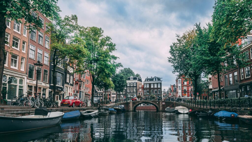 pexels-photo-2031706-2031706 Charming view of an Amsterdam canal lined with bicycles, boats, and historic buildings.